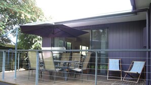 Une terrasse avec des sièges extérieurs et un espace abrité.