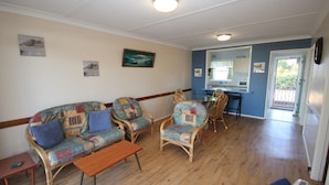 A living room with a sofa, chairs, a coffee table, and a dining area with a table and chairs.