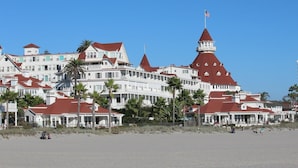 Een groot, meerhoog hotel met een opvallend rood dak en witte muren, met meerdere balkons en een toren waarop de Amerikaanse vlag wappert.