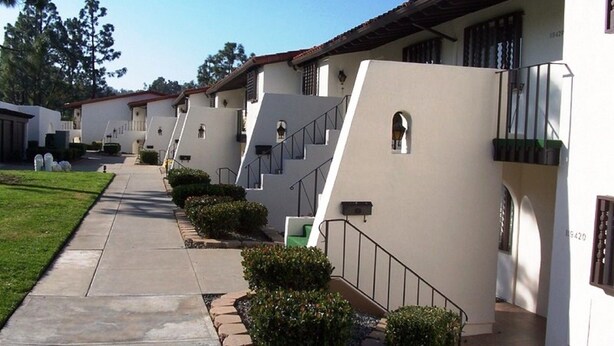 A row of modern, single-story buildings with a uniform architectural style, featuring a clean, white facade and a central staircase leading to a flat roof. - Superb 2 bdrm Rancho Bernardo VillaontheGreen-SWIM.SPA.TENNIS.PICKLEBALL.Pet OK (San Diego)