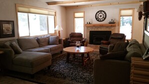 A living room with a sofa, armchairs, a coffee table, a fireplace, and a clock on the wall. - PinecrestAreaRentals #10 Getaway Fall/labor day 3rd night free just Book 2nights (Strawberry)