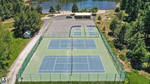 An outdoor tennis court with a net, surrounded by trees and a small building. - PinecrestAreaRentals #10 Getaway Fall/labor day 3rd night free just Book 2nights (Strawberry)