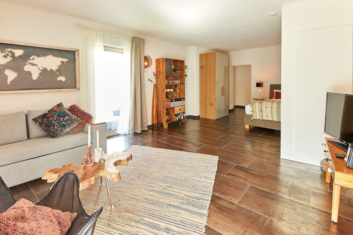 Un salon moderne avec un canapé, une table basse et une carte du monde accrochée au mur.