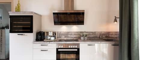 A modern kitchen with a built-in oven, a microwave, a coffee maker, and a sink.