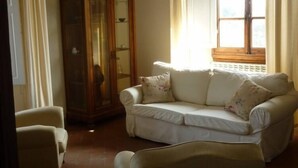 A living room with a sofa, armchairs, a cabinet, and a window with curtains. - THE TERRACE - Apartment in Villa from the beginning of the 20th century (Lastra a Signa)