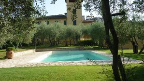 A rectangular swimming pool with a tiled deck, surrounded by a well-maintained lawn and trees. - THE TERRACE - Apartment in Villa from the beginning of the 20th century (Lastra a Signa)