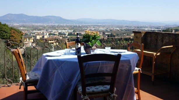 A table set outdoors with a view of a cityscape and mountains in the background. - THE TERRACE - Apartment in Villa from the beginning of the 20th century (Lastra a Signa)