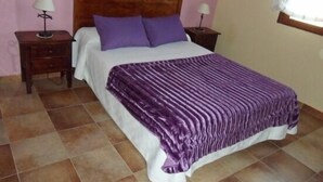 Ein Schlafzimmer mit einem Bett, zwei Nachttischen und einem Fenster.