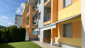 A multi-story residential building with balconies, a paved patio area, and a well-maintained lawn. - Apartment/ flat - Pietra Ligure (Pietra Ligure)