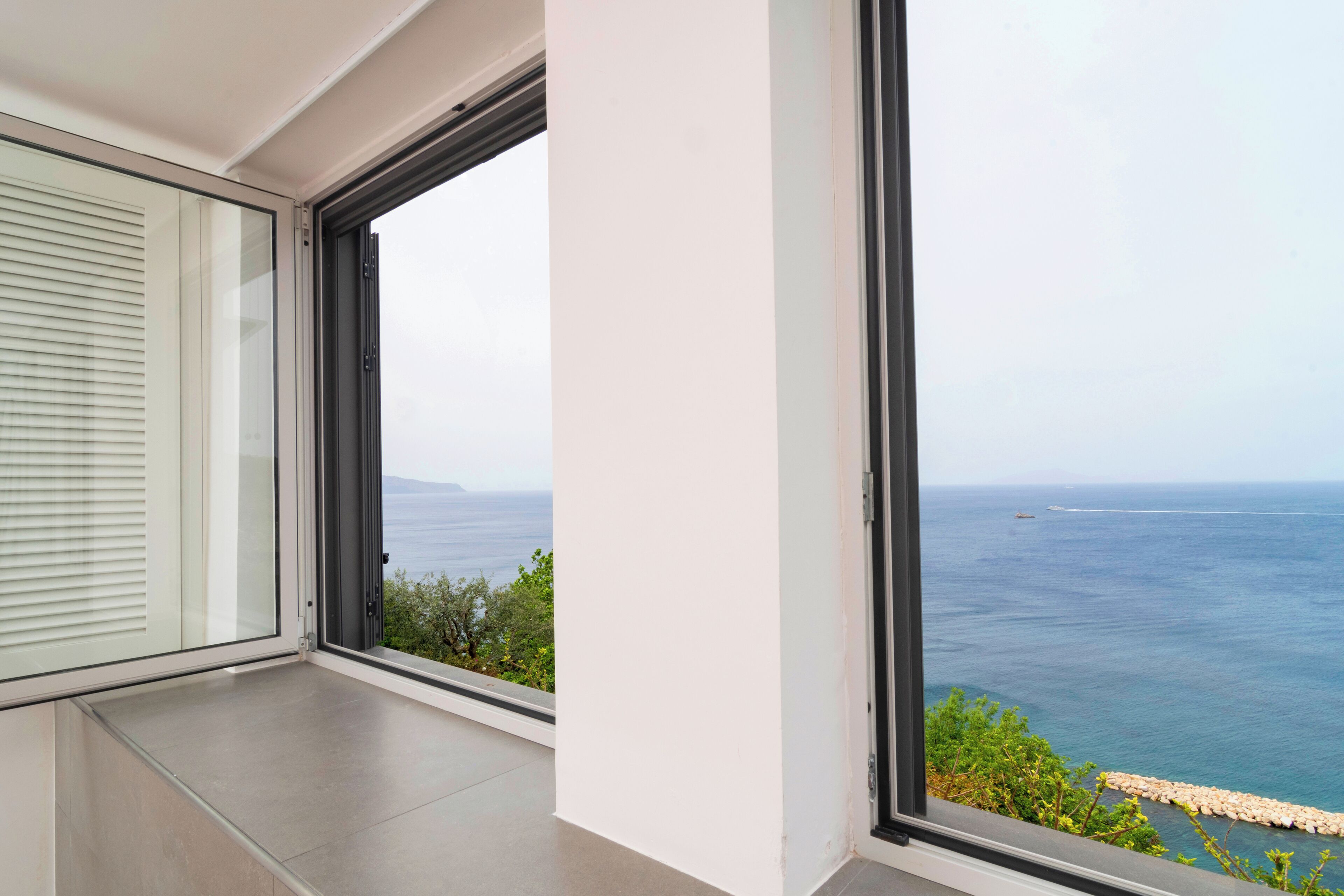 Ein Balkon mit Blick auf das Meer und das entfernte Land.