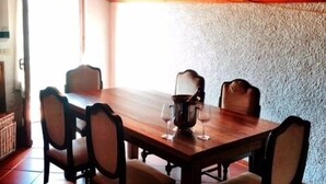 Ein Holztisch mit vier Stühlen, einer Bank und einem Weinglas-Set.