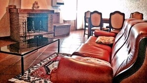 Ein gemütliches Wohnzimmer mit Kamin, Ledersofa und Couchtisch.