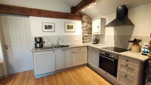 A kitchen with white cabinets, a granite countertop, a built-in oven, a coffee maker, and a toaster.