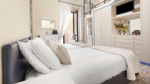 Een hotelkamer met een bed, een kledingkast, een televisie en een badkamer.