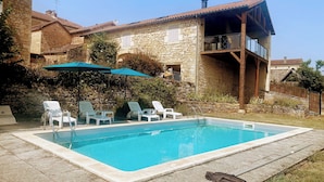A stone house with a swimming pool, outdoor seating, and a balcony. - Luxury renovation of an ancient stone barn in a medieval bastide village (Montcabrier)