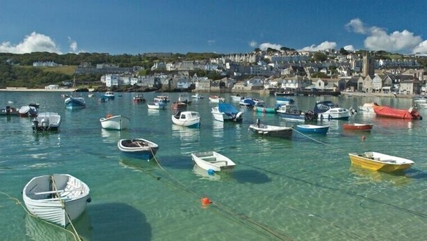 A harbor with numerous small boats anchored in clear water, a town in the background, and a clear sky. - Stunning Luxury Apartment In Carbis Bay, St Ives Close To The Beach with Parking (Carbis Bay, St Ives)