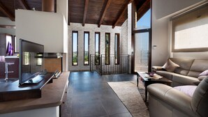 A modern kitchen with a built-in oven and a dining area with a sofa and a coffee table. - Le Orchidee Luxury Country Villa with pool just minutes from the Riviera (Roncofreddo)