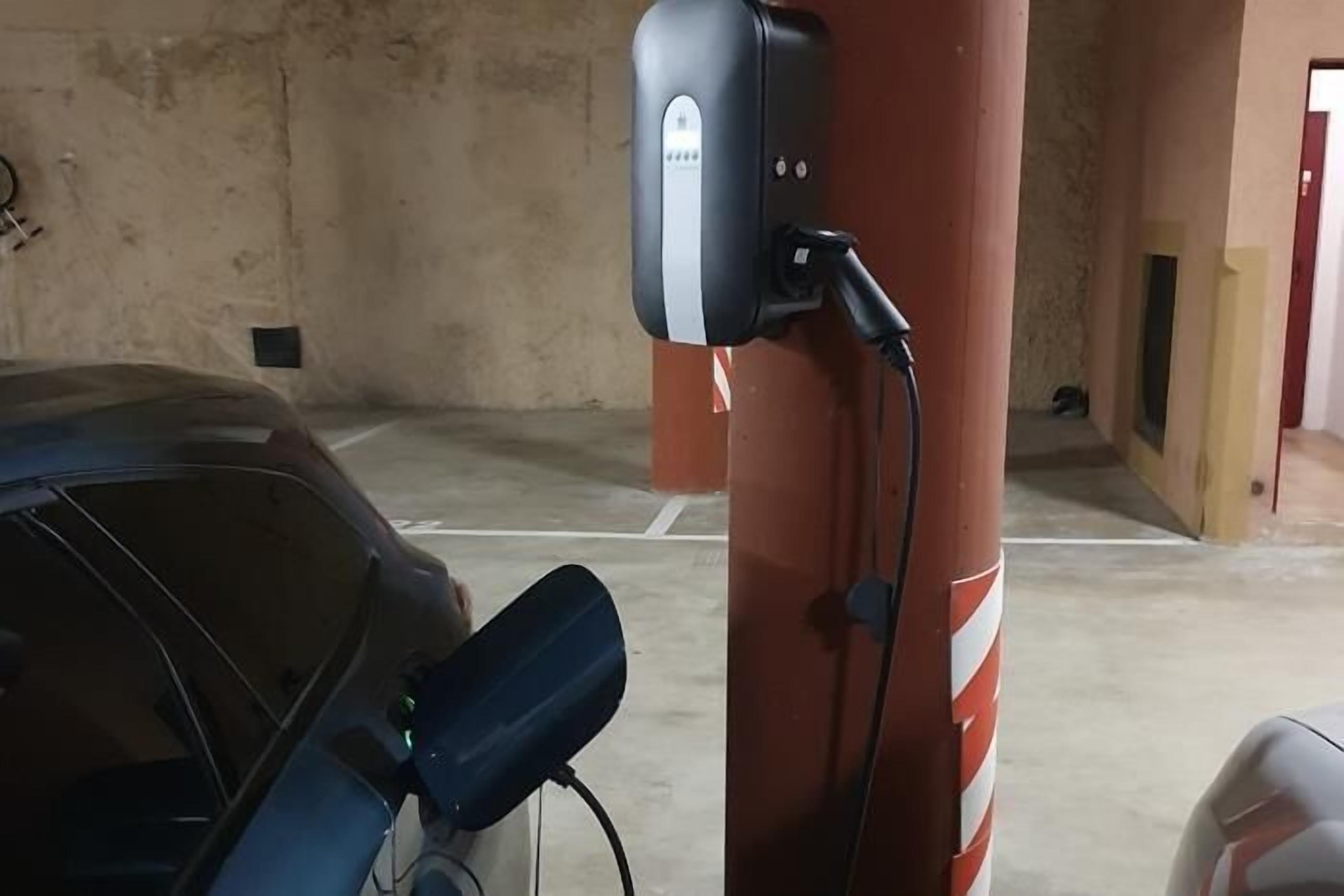 A parking garage with a car charging station.