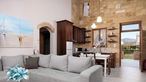 A living room with a sofa, a coffee table with a plant, a kitchen with wooden cabinets, and a dining area.