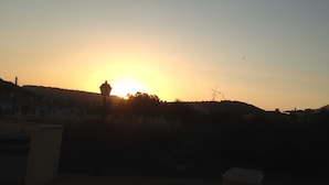 Un atardecer sobre una zona residencial con casas y un farol.