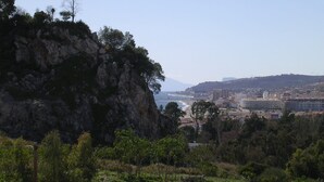 Un paisaje costero con acantilados rocosos, una playa y una ciudad a lo lejos.