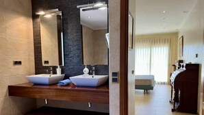 Een moderne badkamer met twee wastafels, een grote spiegel en een houten wastafelmeubel.