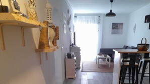 A spacious living area with a wooden floor, a dining table with chairs, a sofa, and a kitchen area with a refrigerator and microwave. - Carvoeiro Travel, 100m from Carvoeiro Beach (Carvoeiro)
