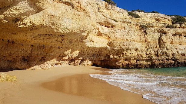 A sandy beach with a rocky cliff in the background. - Carvoeiro Travel, 100m from Carvoeiro Beach (Carvoeiro)