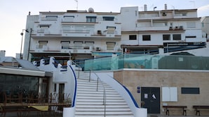 A staircase leading to a building with multiple floors, a restaurant sign, and outdoor seating. - Carvoeiro Travel, 100m from Carvoeiro Beach (Carvoeiro)