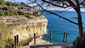 A wooden bench overlooking a rocky coastline with a clear view of the sea. - Carvoeiro Travel, 100m from Carvoeiro Beach (Carvoeiro)