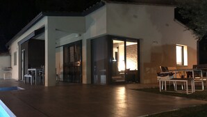 A modern house with a patio, a swimming pool, and a dining area. - New villa with swimming pool in the Costa Brava. Now with WiFi! (Mas Ambros, Calonge)