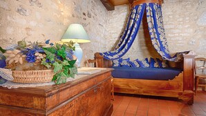 Una habitación rústica con una cama de madera, una mesita de mimbre y una lámpara.