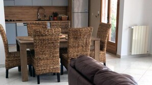 A modern kitchen with grey cabinets, a dining table with wicker chairs, and a brown sofa in the foreground. - Villa with SEA VIEW, 1 km from the BEACH and CITY CENTER, BBQ, TENNIS (Fréjus)