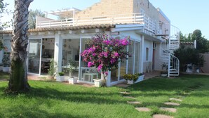 A two-story house with a balcony, a staircase, and a garden with potted plants and a flowering bush. - Wunderbar, Wonderful villa with pool heated (Caucana-finaiti-casuzze-finaiti Nord)
