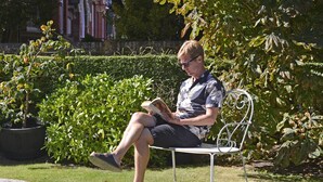 A man sitting on a metal bench in a garden with a book. - Great location - sleeps up to five guests, just moments from the beach and town (Eastbourne)