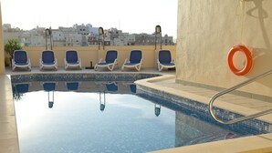 A rooftop pool with clear blue water, surrounded by lounge chairs and a lifebuoy. - Summer Haven, with breathtaking views and Private Swimming Pool (Mellieha)