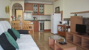 A compact living space with a kitchenette, a dining area, and a seating area with a sofa and a TV. - IDEAL WITH CHILDREN, WIFI, WHITE SAND BEACH. (Costa Calma, Pajara)