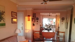 A living room with a sofa, a coffee table, and a dining area with chairs and a table. - APARTMENT CONIL DE LA FRONTERA, GARAGE, WIFI, PROMENADE 5 PERSO (Conil de la Frontera)