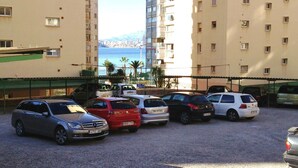 A parking area with several cars, surrounded by high-rise buildings with balconies. - Levante beachfront vacation with spectacular views and sunny terrace (Benidorm)