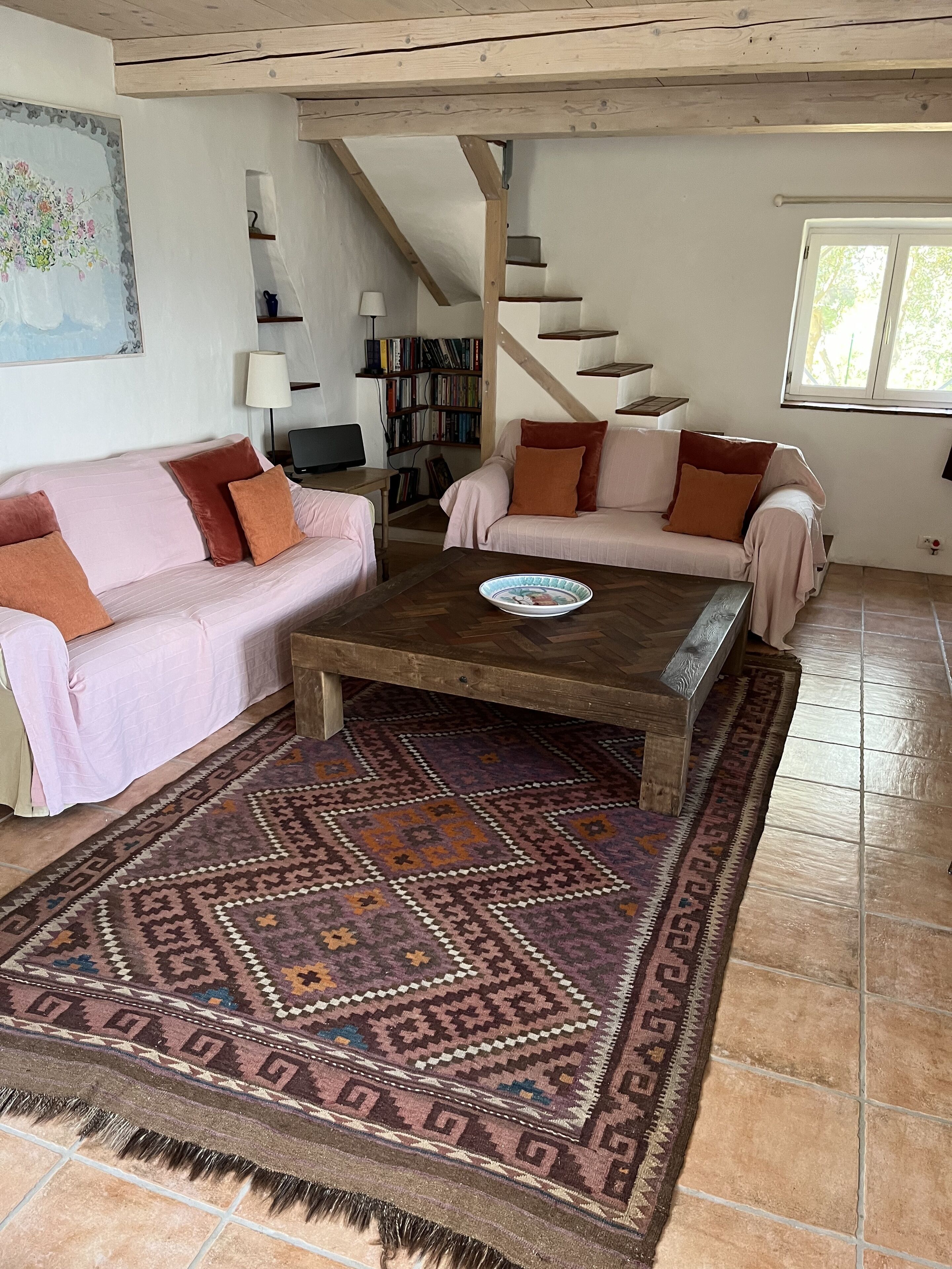 Ein gemütliches Wohnzimmer mit zwei Sofas, einem Couchtisch und einem gemusterten Teppich.