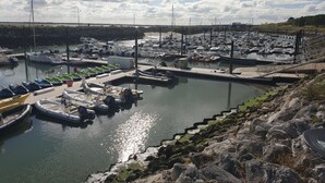 A marina with boats docked, a rocky shoreline, and a cloudy sky. - **** SPACIOUS MOBILE HOME 1/8 PERS LES CHARMETTES **** (Les Mathes)
