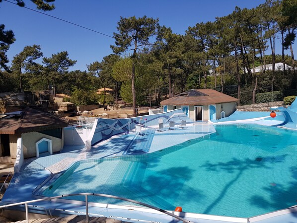 Relax by the pool surrounded by lush greenery and comfortable lounge chairs.