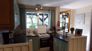 A compact kitchen with a gas stove, a sink, and a window with curtains. - Pretty detached house. not overlooked, swimming pool. near Sarlat/Rocamadour (lachapelle haute)