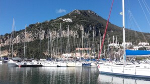 A marina with multiple sailboats docked, a mountainous backdrop, and buildings on the hillside. - Detached house on 2 levels near the sea, newly renovated, super-equipped (San Felice Circeo)