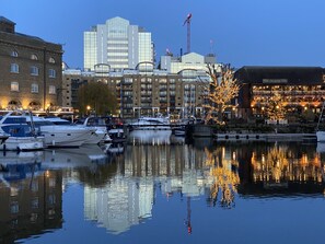 A waterfront hotel with a view of the city skyline, including a prominent building with a glass facade. - Modern London Tower Bridge apartment (London)