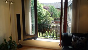 A room with a large open window, a potted plant, and a sofa. - Modern London Tower Bridge apartment (London)