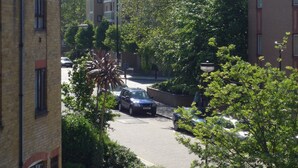 A street view with buildings, cars, and trees. - Modern London Tower Bridge apartment (London)