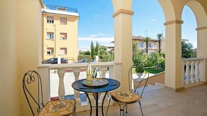 A balcony with a table and chairs, a bottle, and glasses. - Villa Mimosa Near Desenzano Old Town Apt 1 Parking, A/C, WiFi, Desenzano Del Garda, Italy (Desenzano Del Garda)