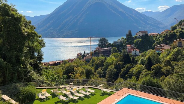A pool area with lounge chairs, a clear view of a lake, and surrounding greenery. - Argegno Home, Argegno, Italy (Argegno)