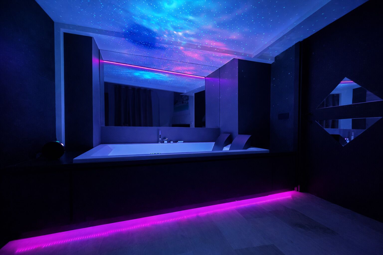 A modern bathroom with a starry ceiling, a large mirror, and a bench.